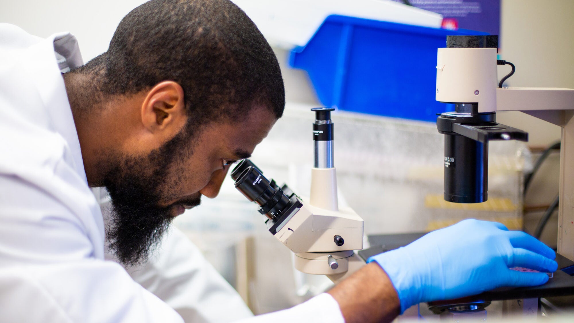 person doing research while looking into microscope